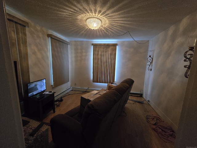 living room featuring a textured ceiling, baseboards, and wood finished floors