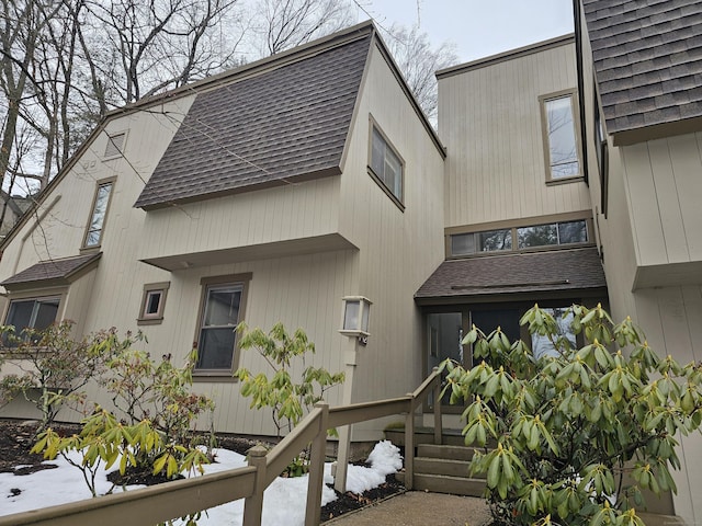 exterior space featuring roof with shingles