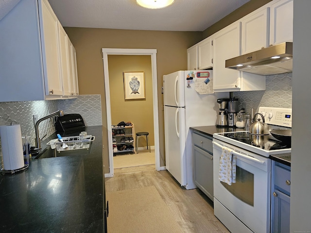 kitchen featuring light wood-style flooring, under cabinet range hood, white appliances, white cabinets, and dark countertops