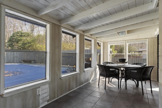 sunroom with wooden ceiling, beam ceiling, and a healthy amount of sunlight