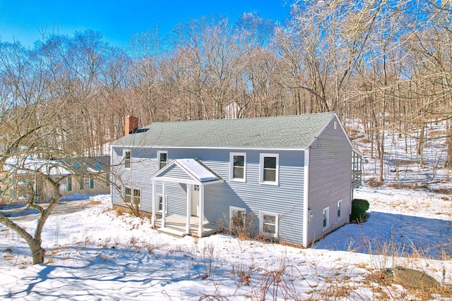 split foyer home with a shingled roof and a chimney