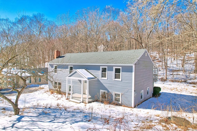 split foyer home with a shingled roof and a chimney