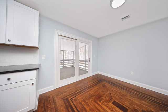 unfurnished dining area featuring baseboards and visible vents