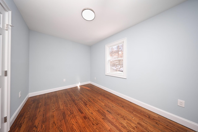 unfurnished room with baseboards and wood finished floors