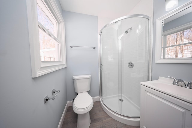 full bath featuring a stall shower, baseboards, toilet, wood finished floors, and vanity