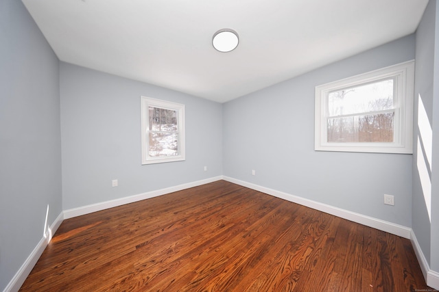 empty room with baseboards and wood finished floors