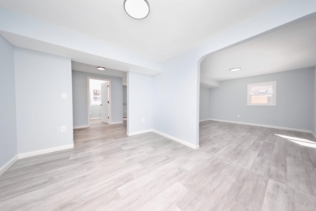 unfurnished room with light wood-style flooring and baseboards