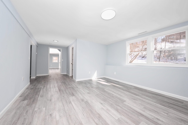 empty room with light wood-type flooring and baseboards