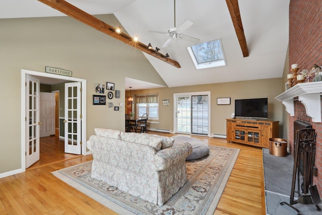 living room with beam ceiling, a ceiling fan, wood finished floors, and french doors