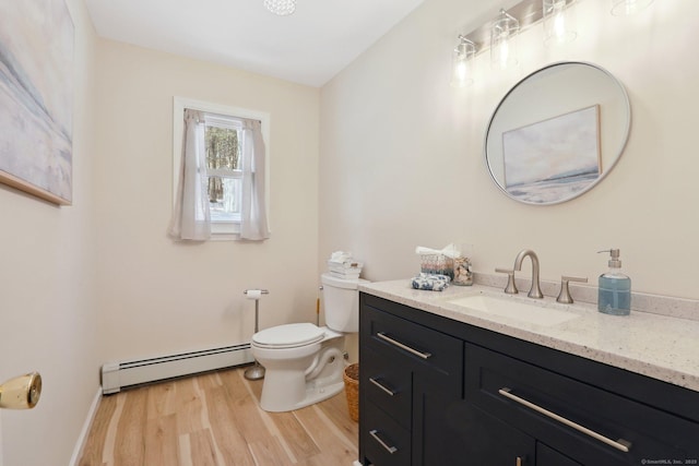 half bathroom featuring toilet, a baseboard heating unit, wood finished floors, vanity, and baseboards