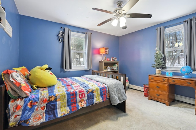 carpeted bedroom with a baseboard radiator, baseboards, and a ceiling fan