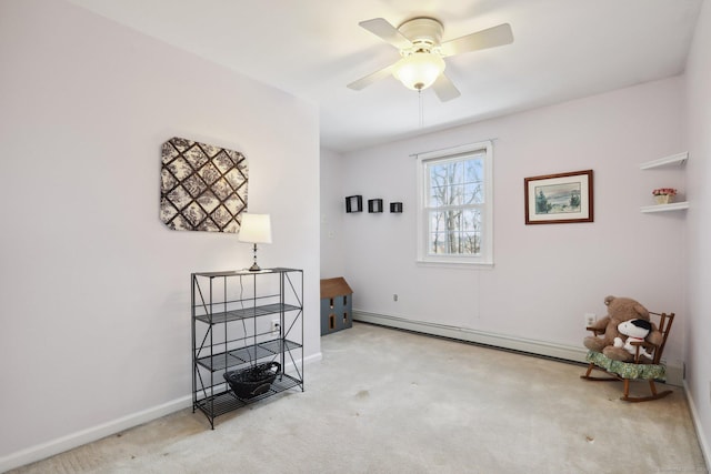 interior space with carpet floors, baseboard heating, a ceiling fan, and baseboards