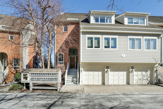 townhome / multi-family property featuring brick siding and roof with shingles