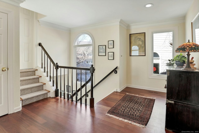 foyer featuring ornamental molding, wood finished floors, a wealth of natural light, and baseboards