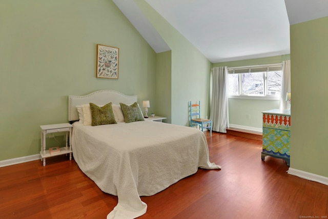 bedroom featuring vaulted ceiling, baseboards, and wood finished floors