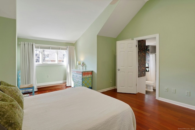 bedroom featuring connected bathroom, vaulted ceiling, baseboards, and wood finished floors