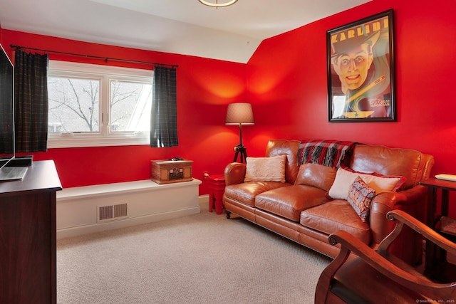 carpeted living area with visible vents, vaulted ceiling, and baseboards