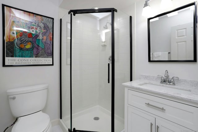 bathroom with a stall shower, vanity, and toilet