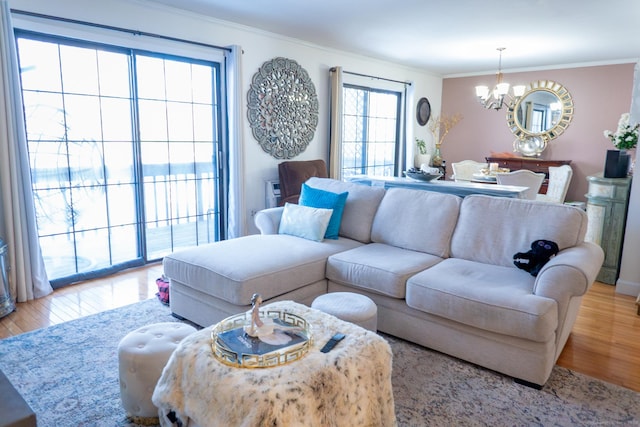 living room featuring a chandelier, ornamental molding, and wood finished floors