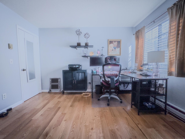 office area with a baseboard radiator, baseboards, and wood finished floors