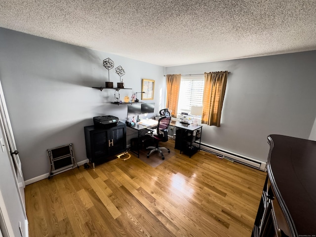 unfurnished office with a textured ceiling, a baseboard radiator, baseboards, and light wood-style floors