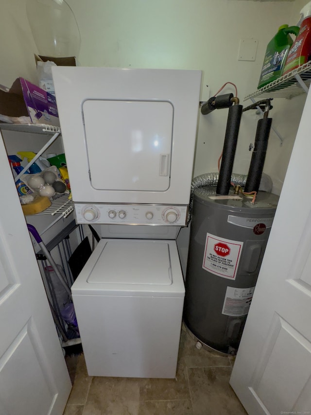 washroom with electric water heater, stacked washer and dryer, and laundry area