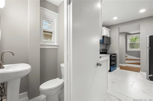 half bathroom with toilet, marble finish floor, baseboards, and recessed lighting