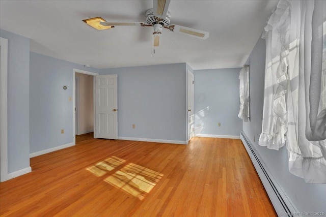 unfurnished room with a ceiling fan, baseboards, light wood finished floors, and baseboard heating