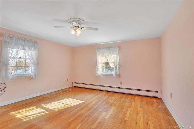 unfurnished room with light wood finished floors, a baseboard radiator, a ceiling fan, and baseboards