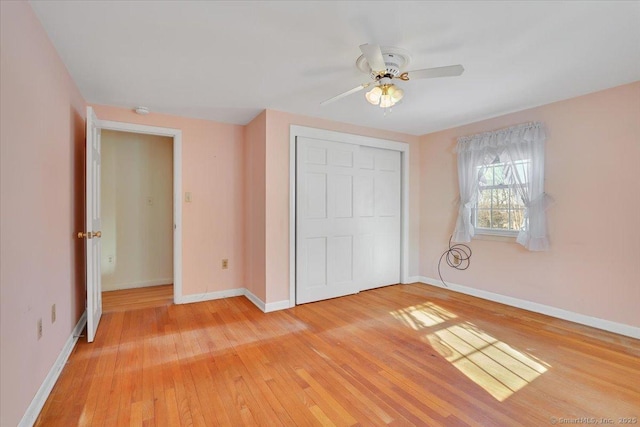 unfurnished bedroom with light wood-style flooring, baseboards, and a closet