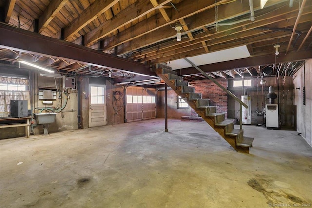 below grade area featuring water heater, stairway, a heating unit, a sink, and electric panel