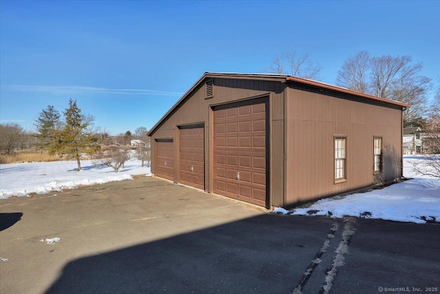 snow covered structure with an outbuilding