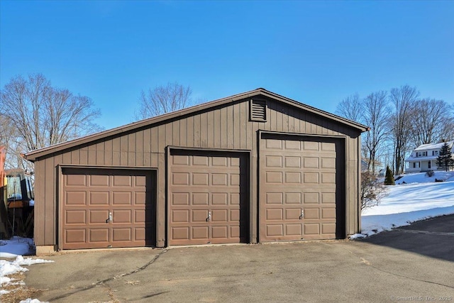 snow covered garage featuring a garage