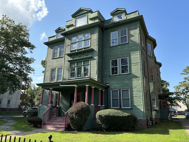 view of front of house with cooling unit and a front lawn