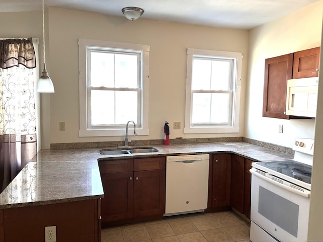 kitchen with white appliances, a sink, a peninsula, and light tile patterned floors