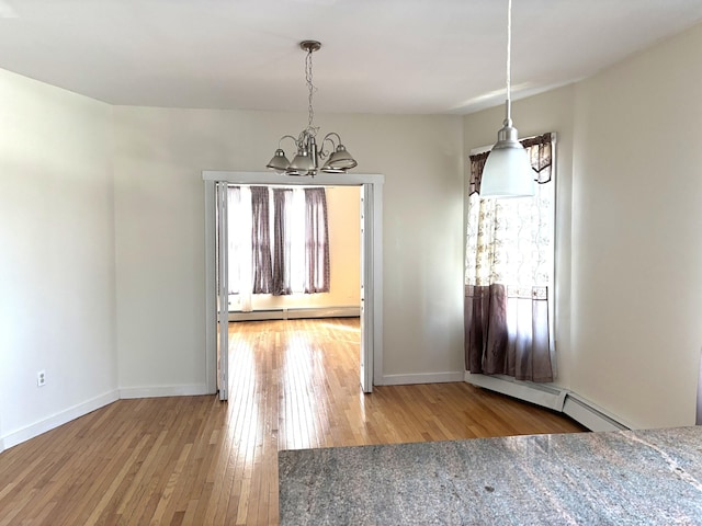 unfurnished dining area featuring baseboards, a baseboard radiator, hardwood / wood-style floors, baseboard heating, and a notable chandelier