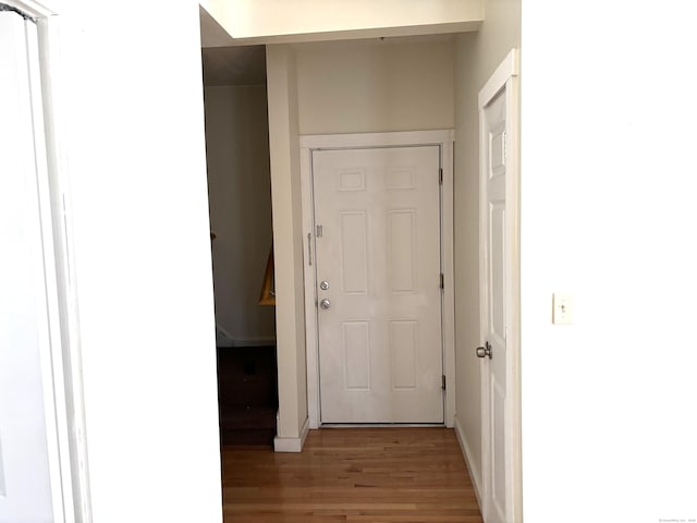 hallway with light wood-style flooring and baseboards