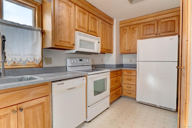 kitchen featuring white appliances, light countertops, a sink, and light floors