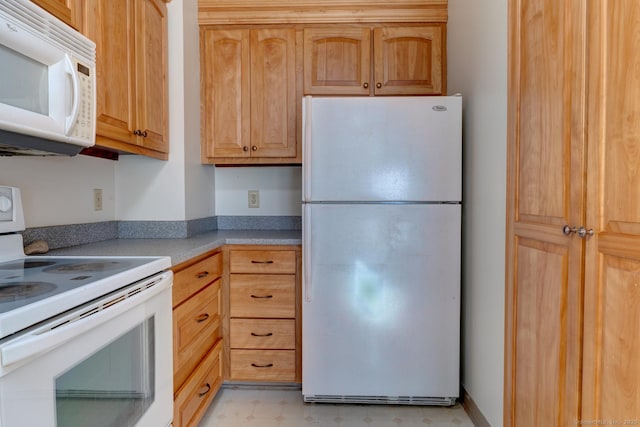 kitchen featuring light floors, white appliances, and light countertops