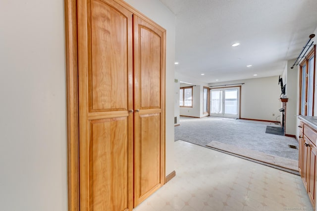 interior space with light floors, recessed lighting, baseboards, and light colored carpet