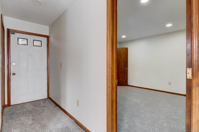 foyer entrance with recessed lighting, light carpet, and baseboards