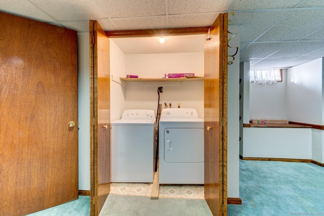 washroom with baseboards, light carpet, and washing machine and clothes dryer