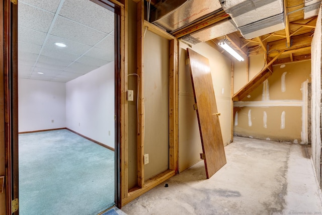 unfinished below grade area featuring a drop ceiling and baseboards