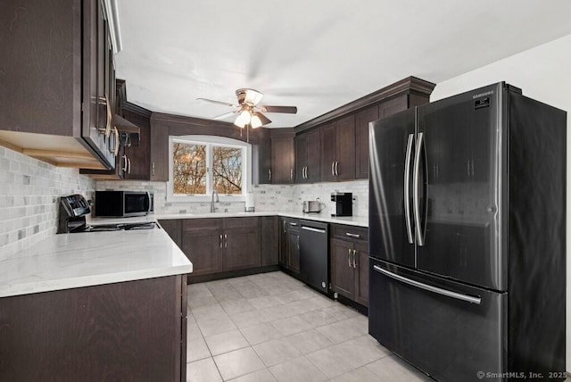 kitchen with dark brown cabinetry, a sink, light countertops, appliances with stainless steel finishes, and tasteful backsplash