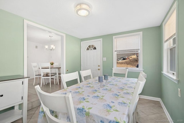 dining area featuring a notable chandelier, baseboards, and light tile patterned floors