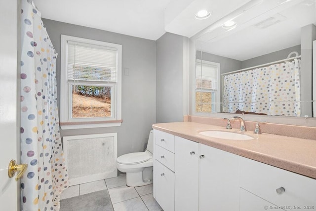 full bathroom with a healthy amount of sunlight, vanity, toilet, and tile patterned floors