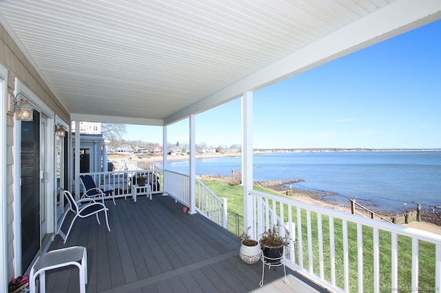 deck with a water view and a yard