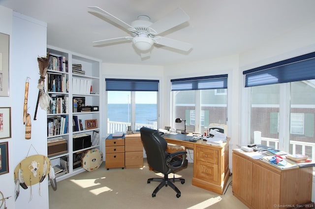 office with ceiling fan, a water view, and light colored carpet