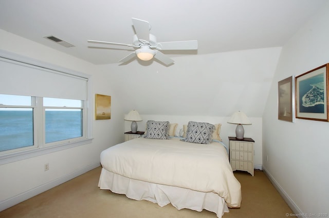 bedroom featuring baseboards, visible vents, light colored carpet, lofted ceiling, and a water view