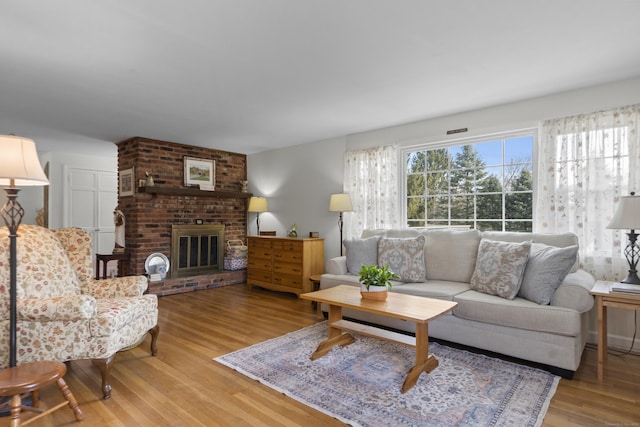 living area with a fireplace and wood finished floors